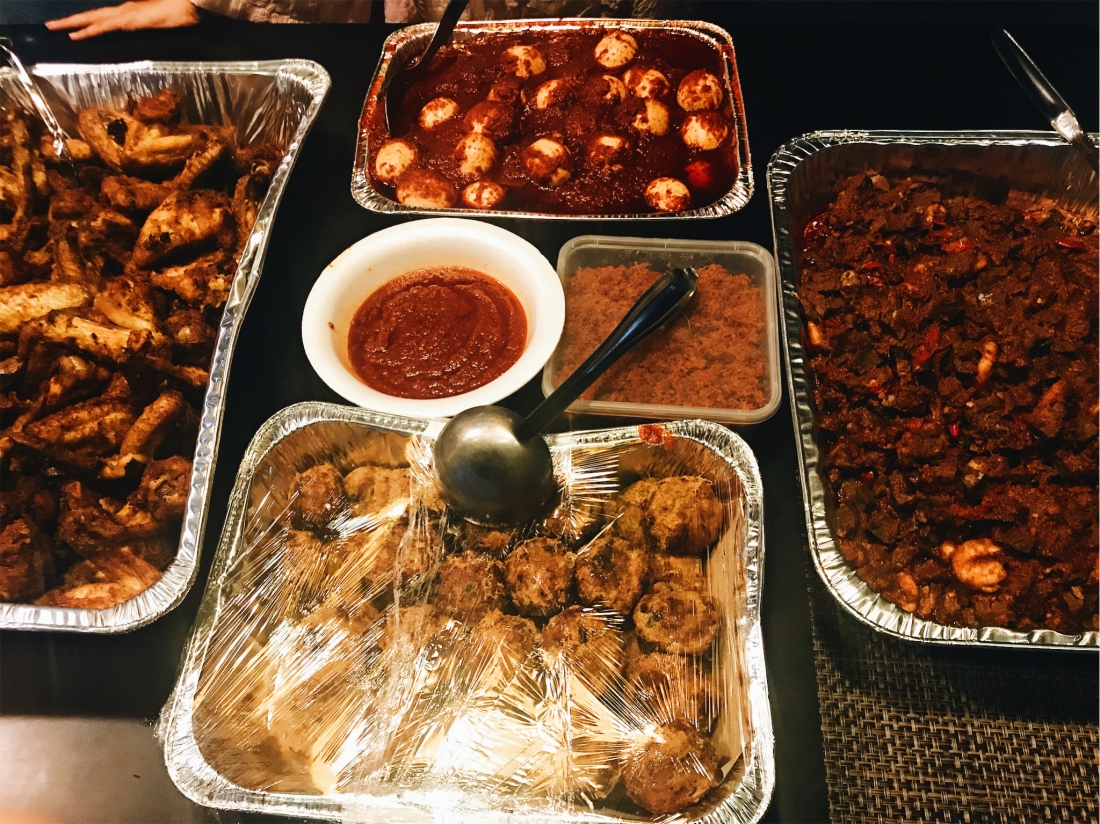 Spread of hari raya food set on a table. From left in clockwise direction is fried chicken, sambal telur, sambal goren pengantin, begedil, sambal and serunding